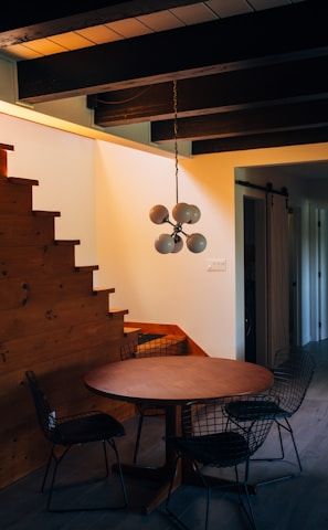 round brown wooden table and chairs under white pendant lamp