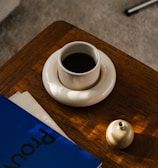 a cup of coffee and a book on a table